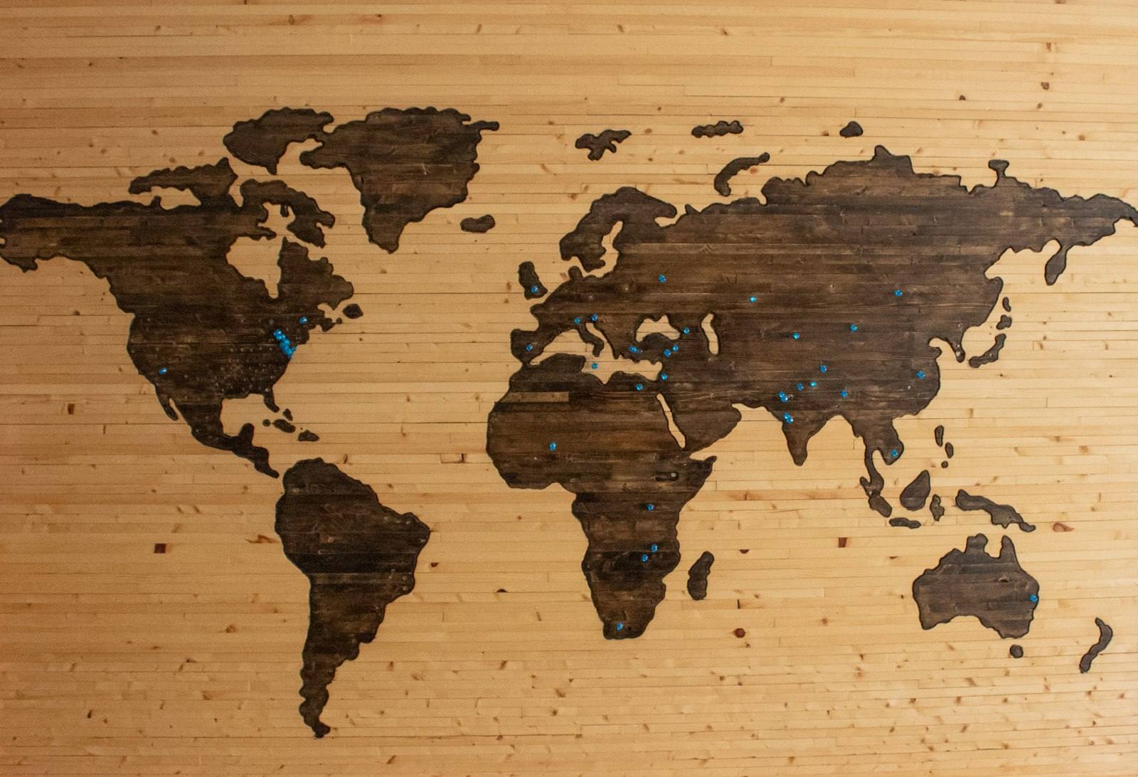 A world map carved into a wooden wall panel