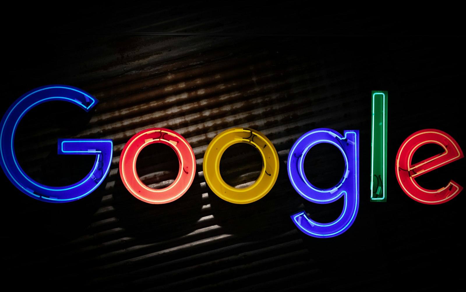 The Google logo rendered in neon lighting on a dark wall